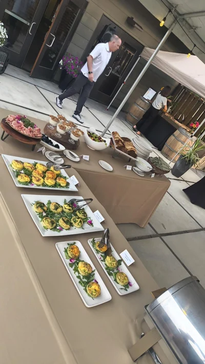 Catered brunch spread with mini quiches, pastries, parfaits, and charcuterie.